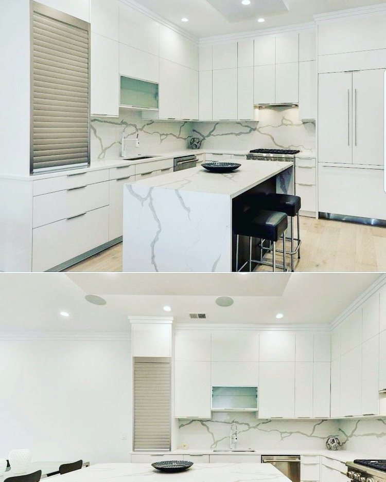 vitt kök med marmorö och bakvägg med rullskåp i aluminium