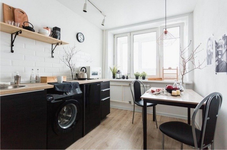 svart kök och svart tvättmaskin med bänkskiva i trä