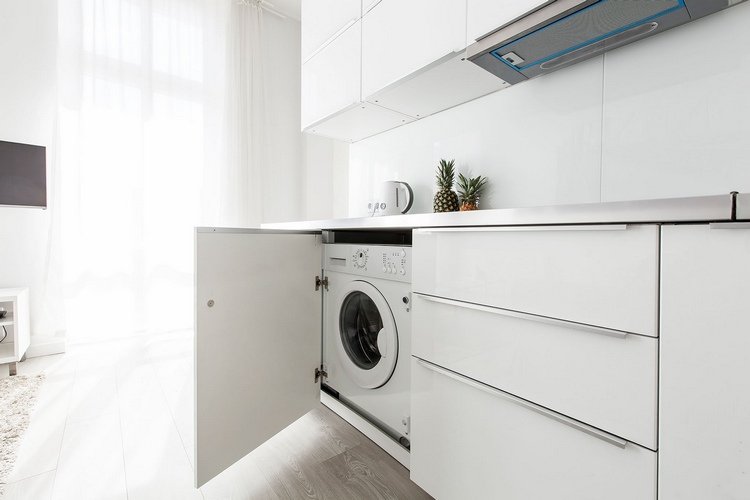Tvättmaskin i kök med dörrklädd