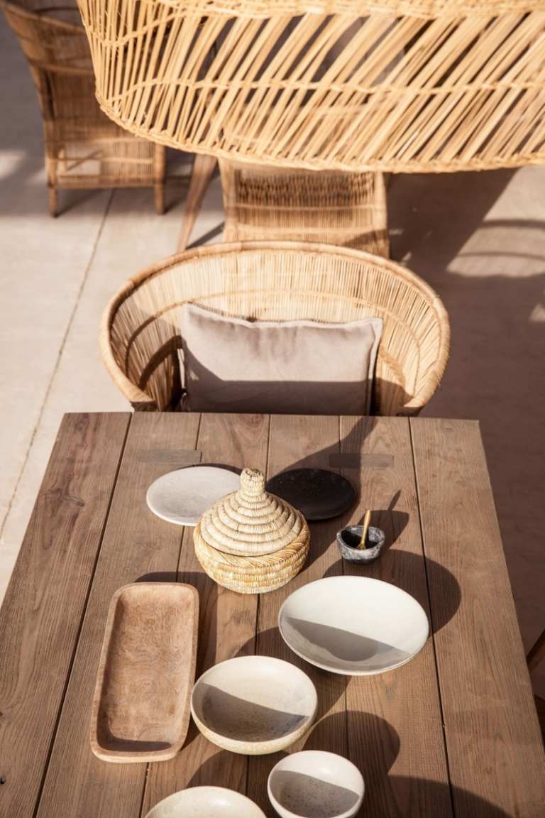 medelhavs-terrass-kalksten-trä-bord-naturligt-trä-stol-korg-rätter-traditionell-sol