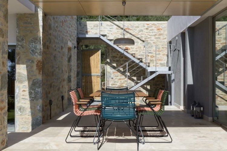 Medelhavet-vägg-sten-pelare-blå-röda-stolar-matsal-utomhus
