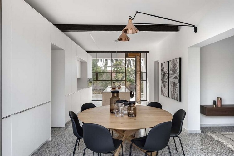 matplats med ett runt designbord och svarta matstolar i en modern atmosfär med vita köksmöbler