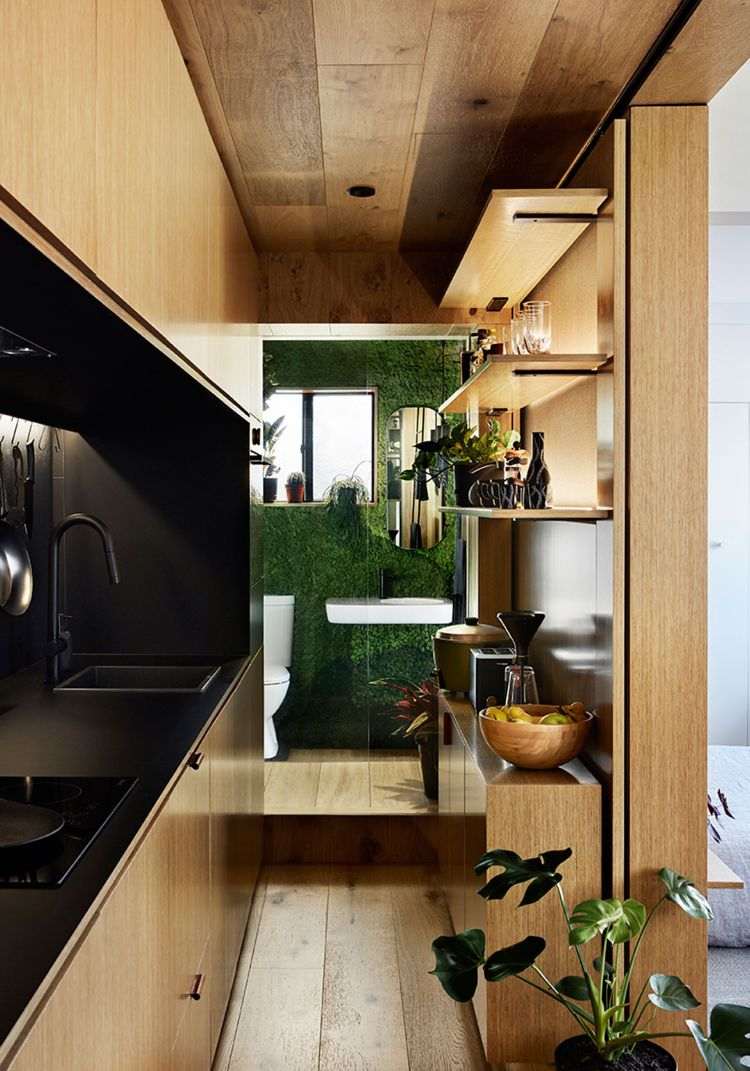 Mikro lägenhet inredning minimalistisk design 70 -tals stil träpanel kök badrum mossa grön växt vägg levande