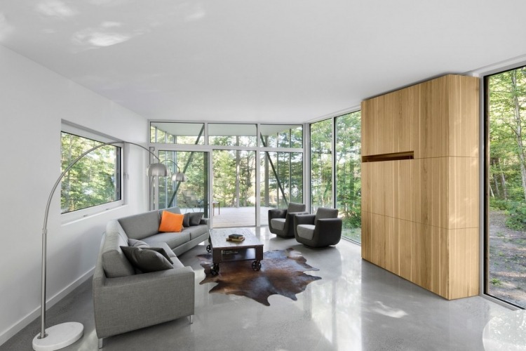 minimalistisk-levande-natur-modernt-hus-vardagsrum-betong-golv-soffa-päls-matta-golvlampor