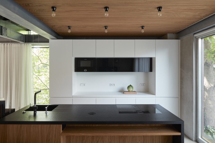 minimalistisk inredning betongträ modernt kök med svart bänkskiva