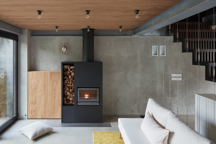 minimalistisk inredning betong trä vardagsrum öppen spis vit soffa