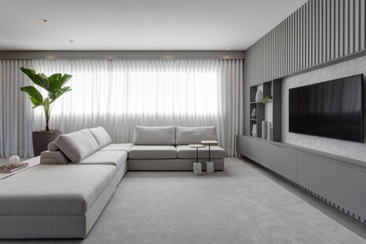 Mattgrått kök och stor vit soffa med utsikt över TV -väggen