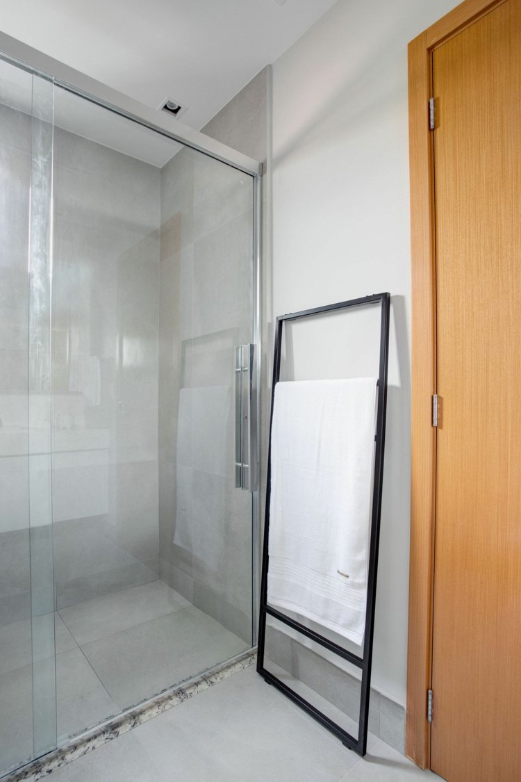 Stor dusch med skjutdörrar och svart handduksställ