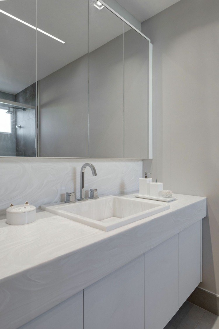 Kök i mattgrått som kontrast till det vita badrummet i attraktiv vit sten