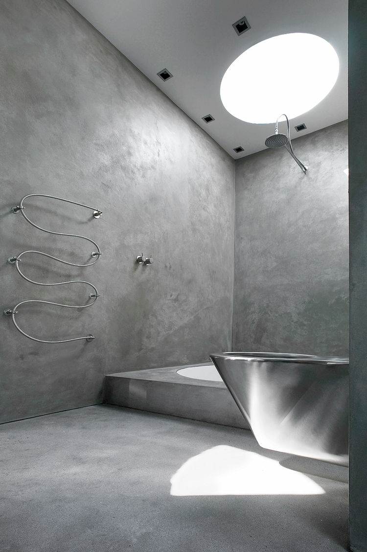 minimalistisk badrumsdesign betonglook badkar sluttande tak svartvitt