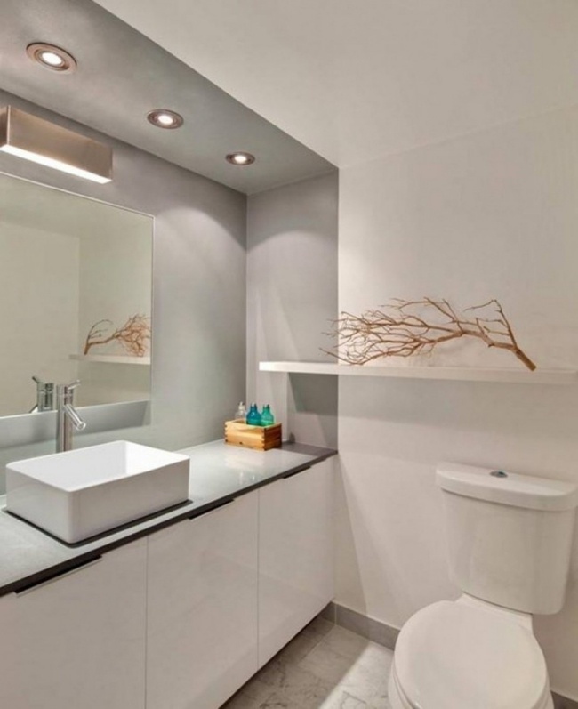 minimalistisk badrumsdesign vit grå infällda lampor handtagfria fronter