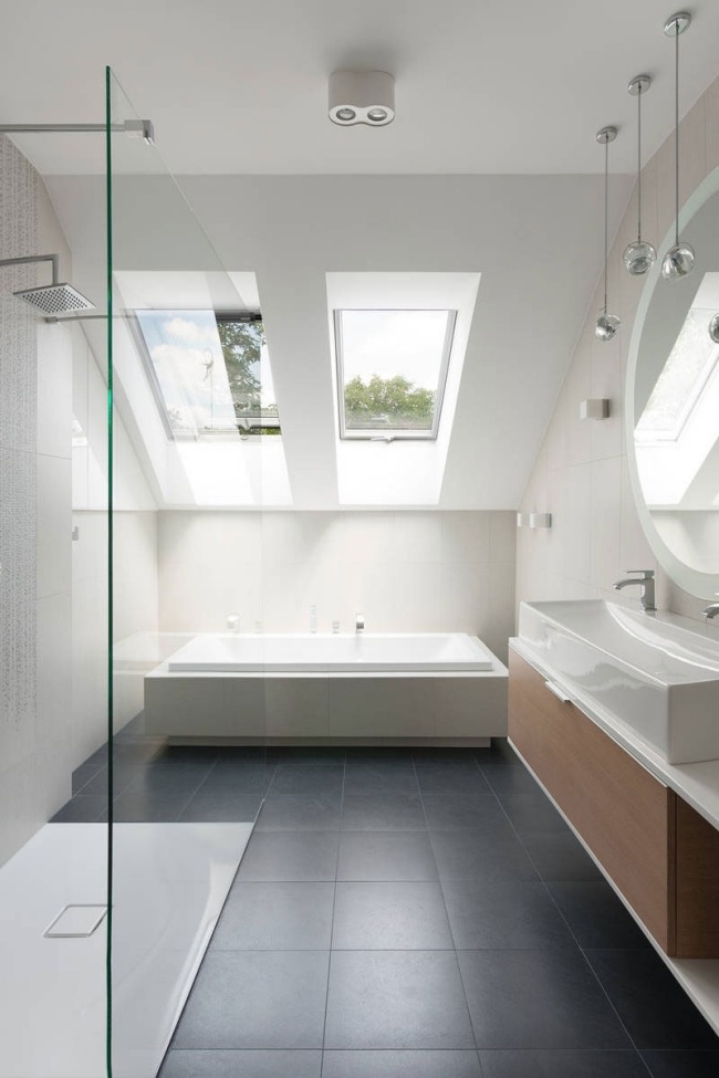 minimalistiskt badrum sluttande tak grå golvplattor badkar