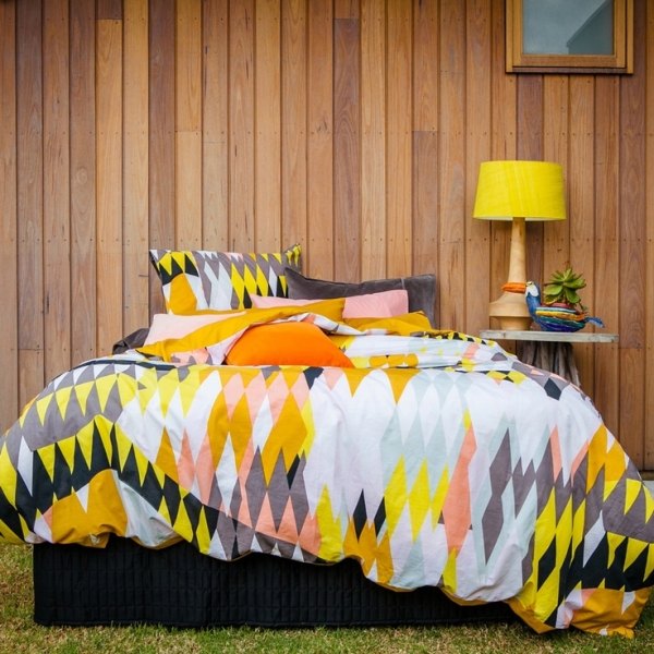 Sovrum som dekorerar lakan och kuddar mönster färgglad bordslampa