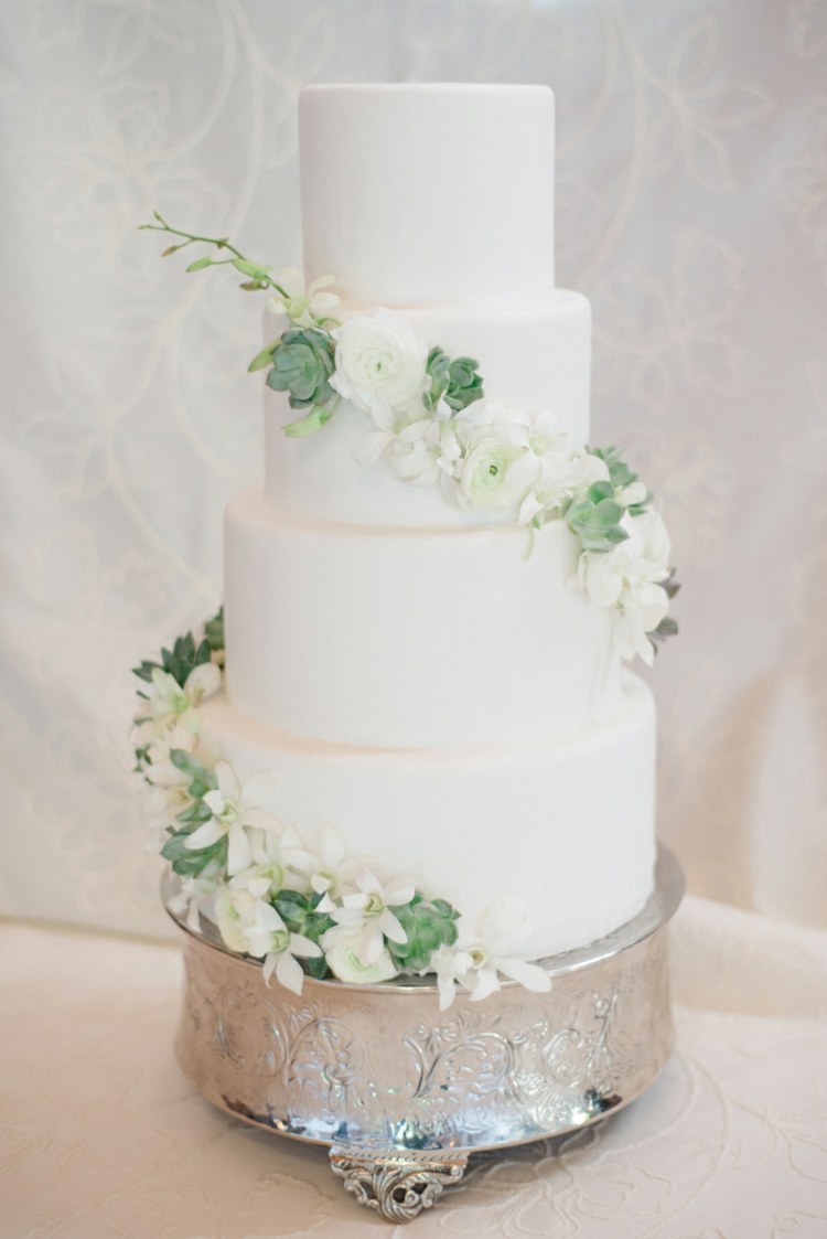 Vintage krans med vita blommor och succulenter dekorerar bröllopstårtan
