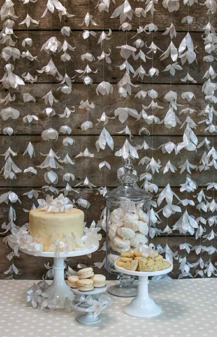 DIY -gardin gjord av pappersblommor som bakgrund för dessertbordet