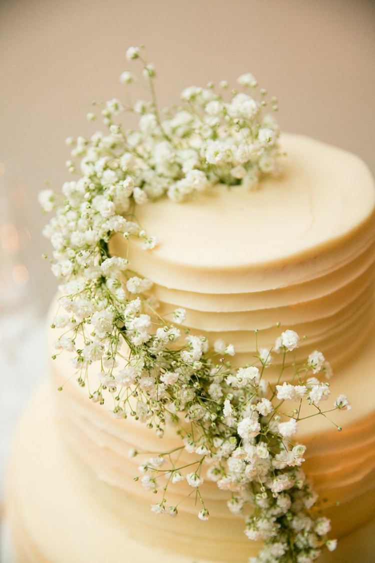 designa bröllopstårtan med en vit blommekrans för bröllopet