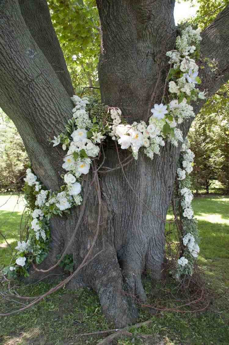 Fira utomhusbröllop och dekorera träd med blommor