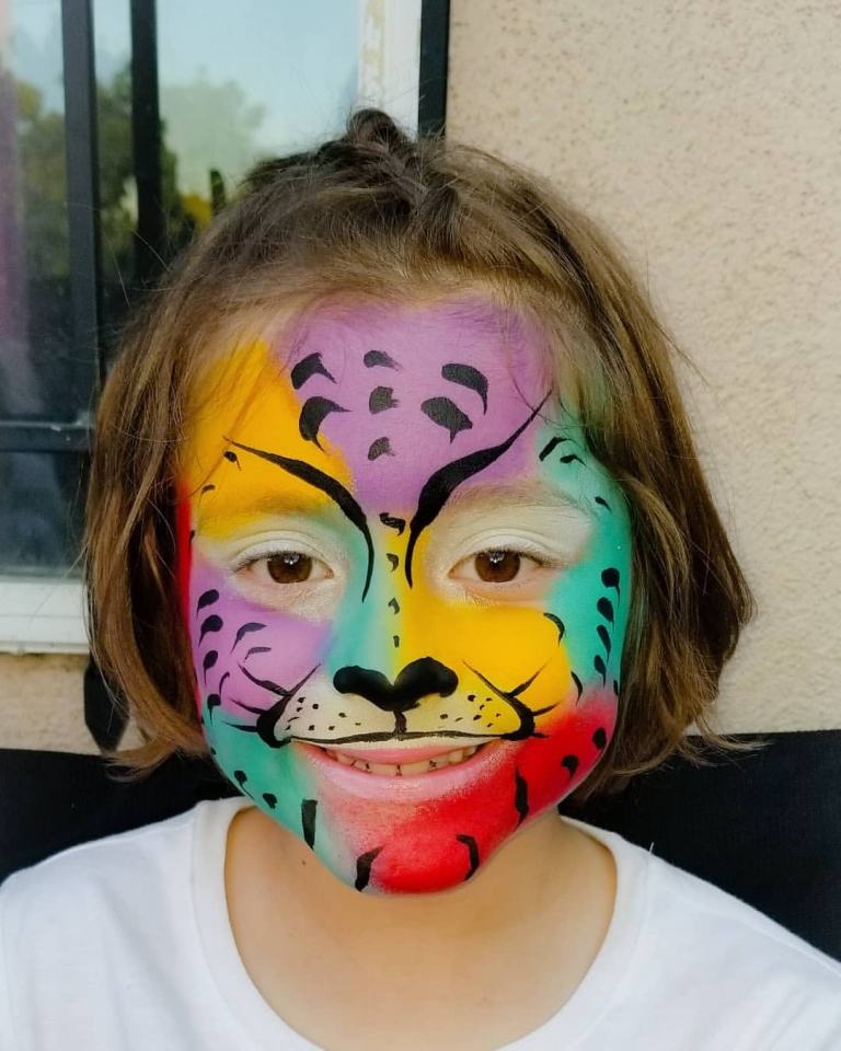 Cheetah-sminkflicka med färgglada ansiktsmink-idéer för katt