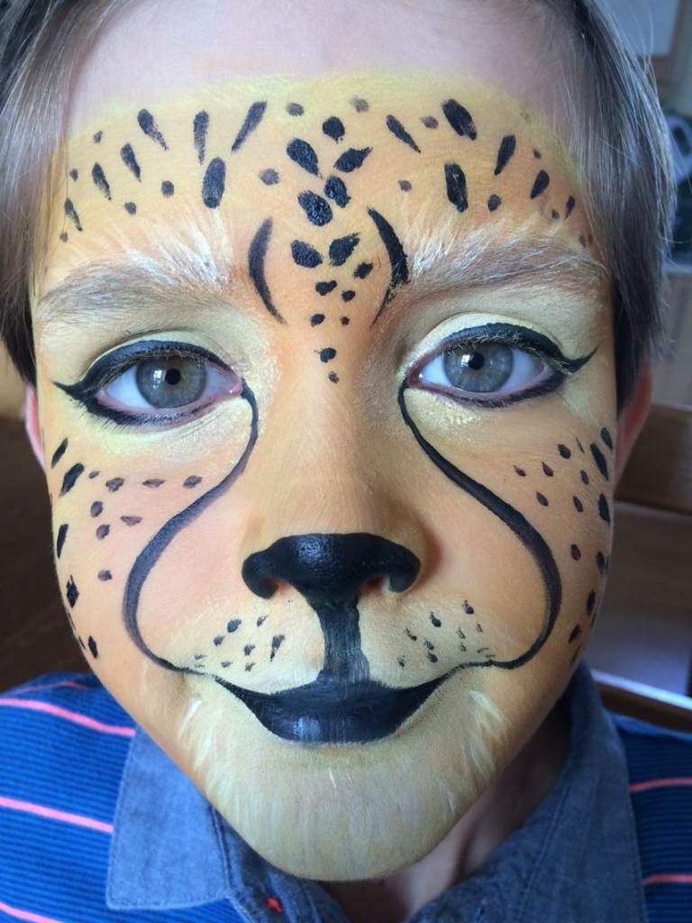 Gepard som applicerar smink Halloween-makeupidéer för barn Pojke med sminkat ansikte