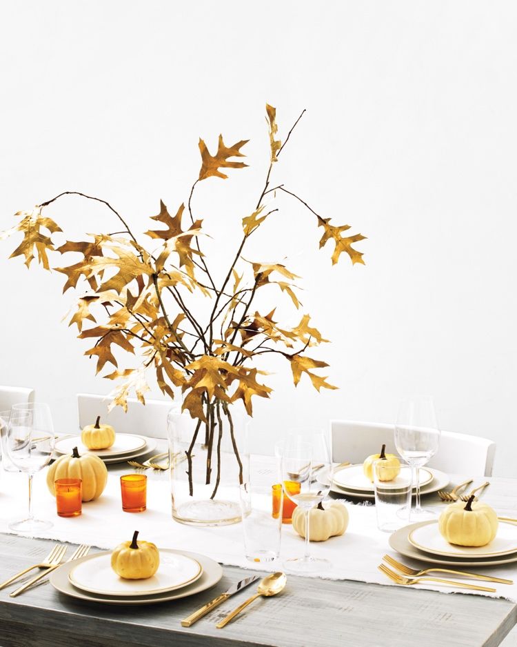 Herbstdeko bord modernt med höstlöv och pumpor och gyllene bestick