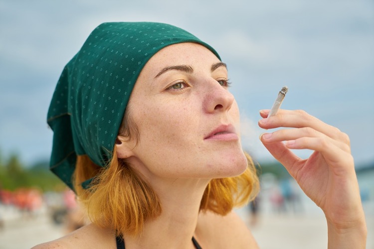kvinna med huvudduk och tobakscigarett ute på sommaren