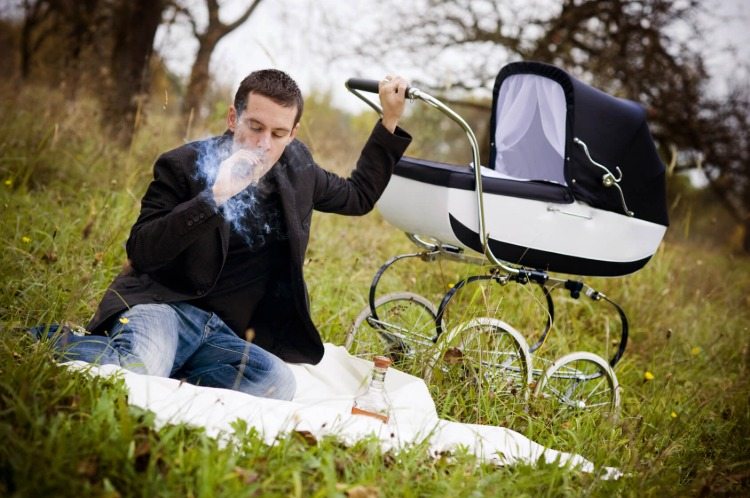 far röker cigarr mitt i naturen med barnvagn i retrostil