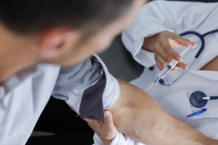 Läkare injicerar mmr-vaccination i patientens arm med covid-19