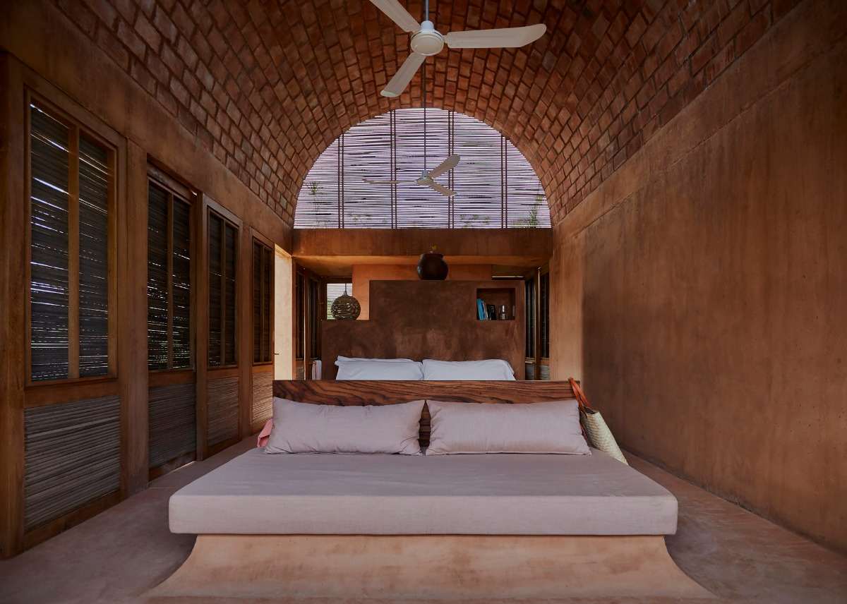 rymligt sovrum med dubbelsäng och tak av tegelsten rustik design