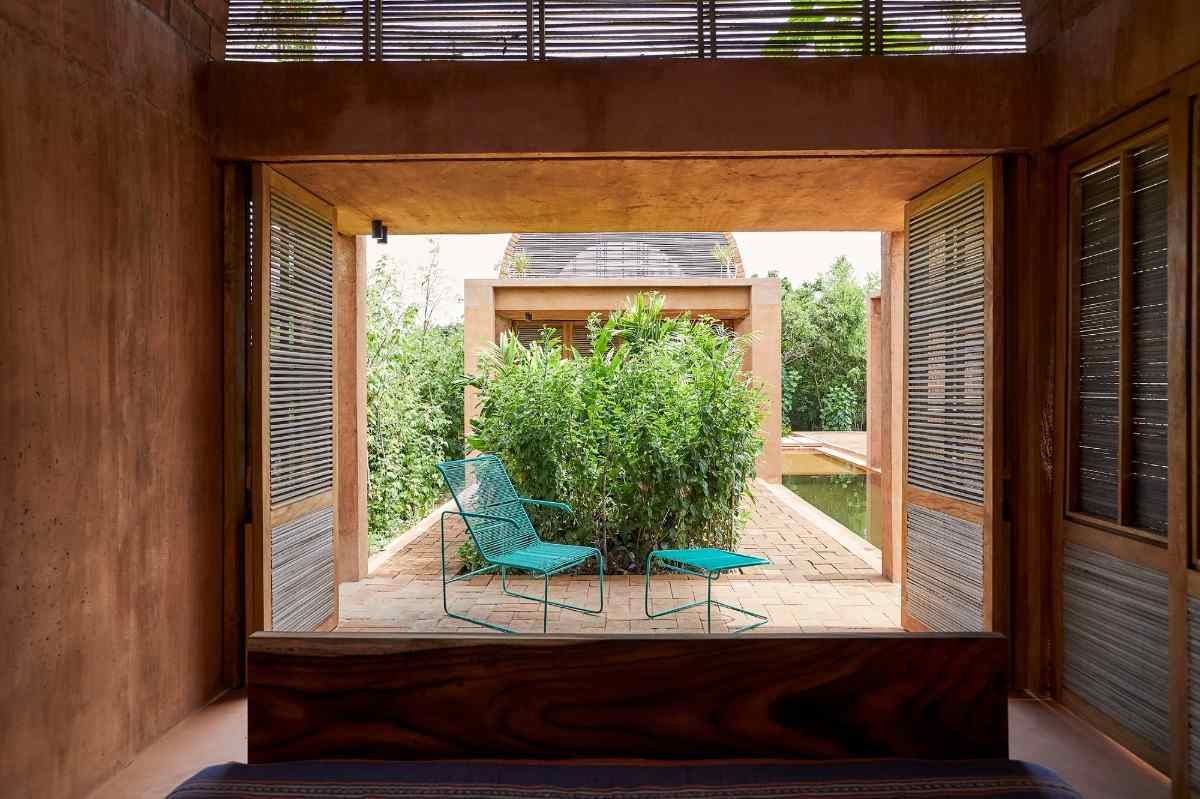 designerstol med sidobord i grönt framför sovrummet på innergården