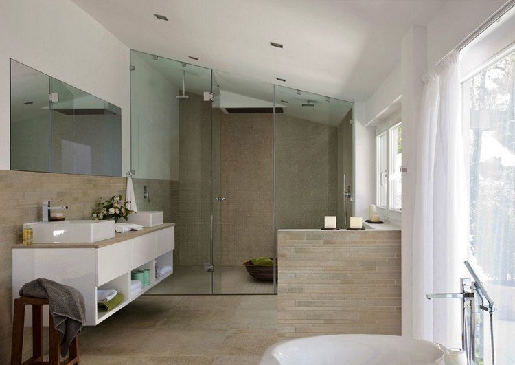 Modernt badrum sluttande tak-glas dusch-beige-golvplattor-natursten utseende