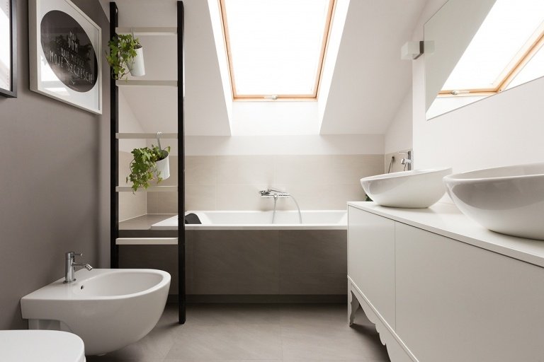 moderna badrum med snett tak och kakel i neutrala färger möbler med bidé och badkar