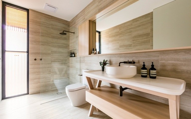 Moderna badrum med duschkabin och naturstenskakel på väggen, regndusch och trähandfat med bänkskåp
