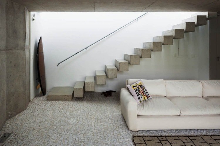 modern-betong-trappbyggnad-minimalistisk-soffa-grädde-vit-ljus-gips-räcke-metall