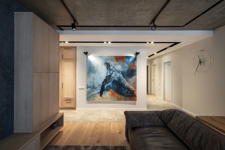 abstrakt konstbild väggbelyst soffskåp trägolvgrått betongtak