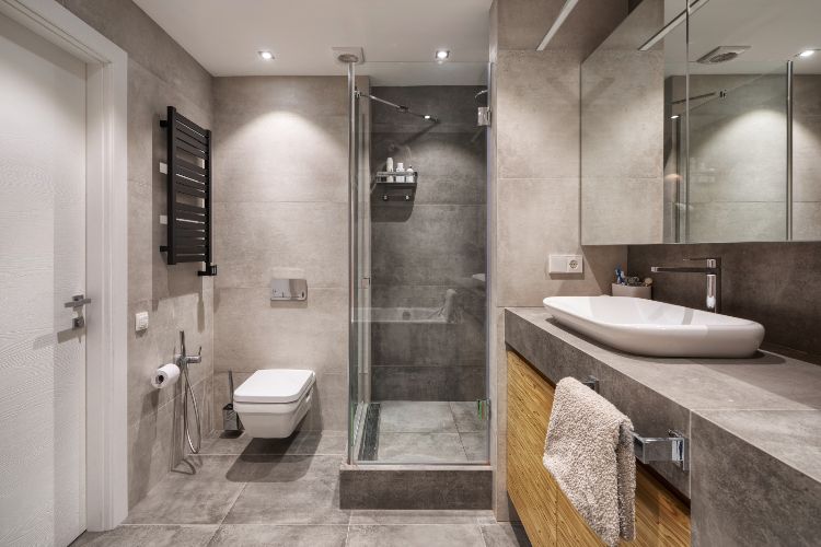 badrum duschkabin handfat radiator kaklad grå spegel