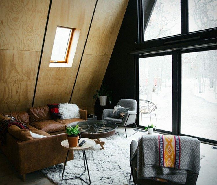 vardagsrum relaxavdelning skinnsoffa matta fönster fram modern finnhütte