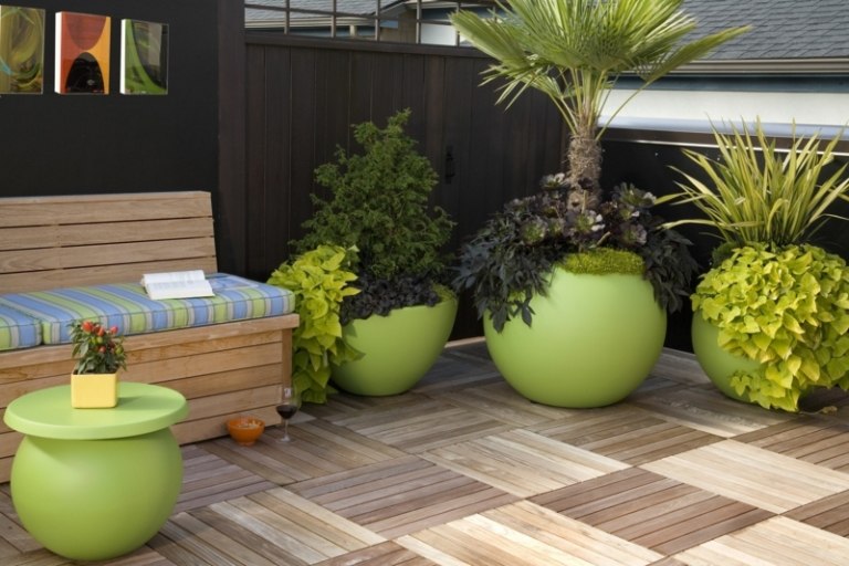 moderna trädgårdsdesign exempel blomkrukor grön färg palmer terrass