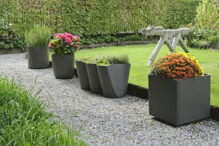 modern trädgård design exempel metall planter svart häck trädgård väg grus