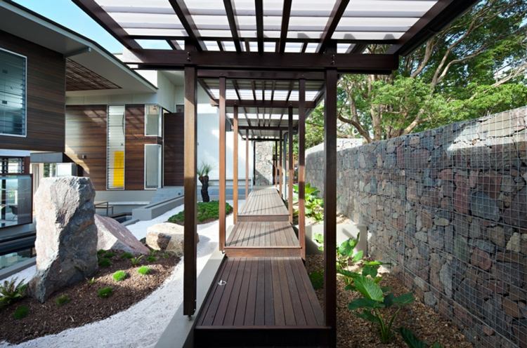 modern-trädgård-design-sten-skulptur-bro-trä-pergola-gabioner