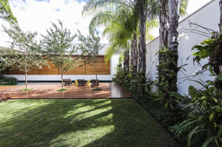 Modern trädgård design-trä fasad-gräsmatta-palm-växter-trä golv-pool-stolar