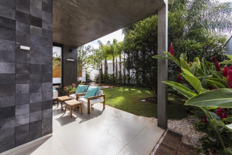 modern-trädgård-design-trä fasad-utomhus-växter-palmer-gräsmatta-tak-sittplatser