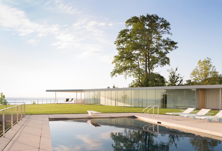 Modernt glas fram-hus-pool-trädgård-gräsmatta-terrass-havsutsikt