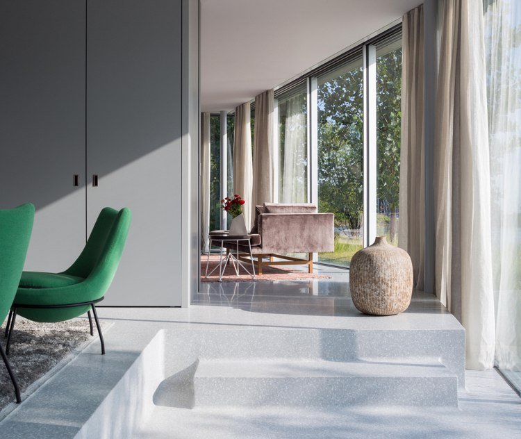 modernt glas-fram-vardagsrum-betong-golv-pastellfärgad gardin