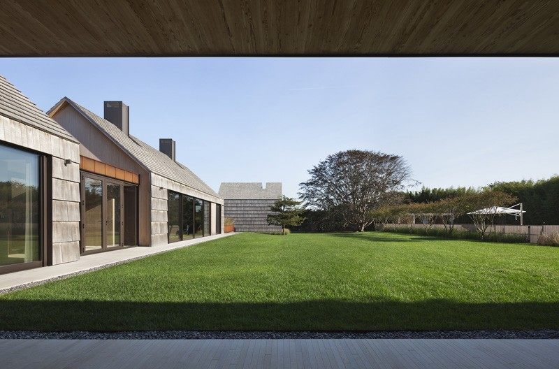 Modern träfasad-trä bältros-gräsmatta-trädgård-träd-terrass-dörrar