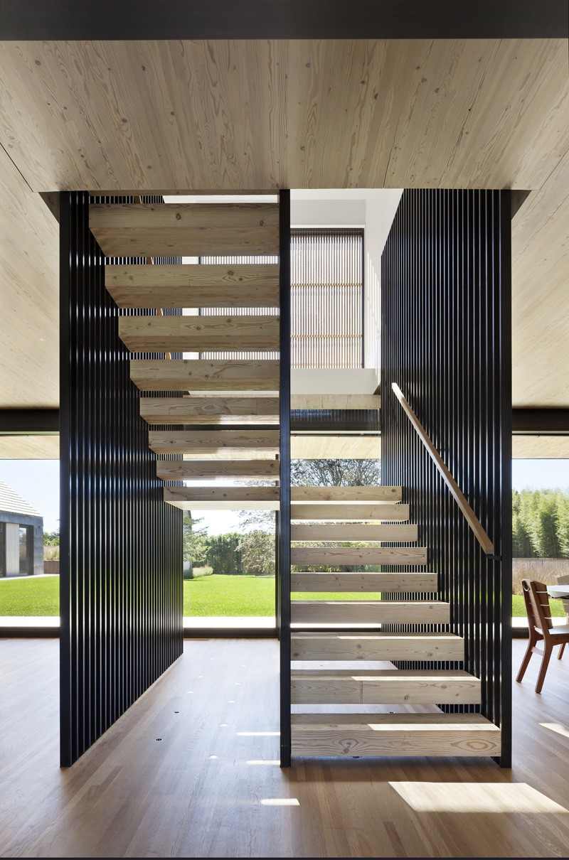 modern-trä-fasad-trä-trappor-räcke-stål-hål-i-mitten-andra-våningen
