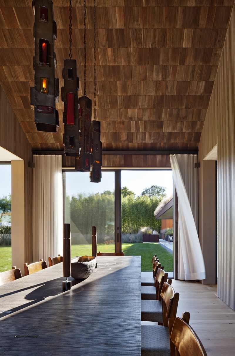 modern-trä fasad-trä bältros-matbord-stolar-vintage-fönster-vägg-taklampor