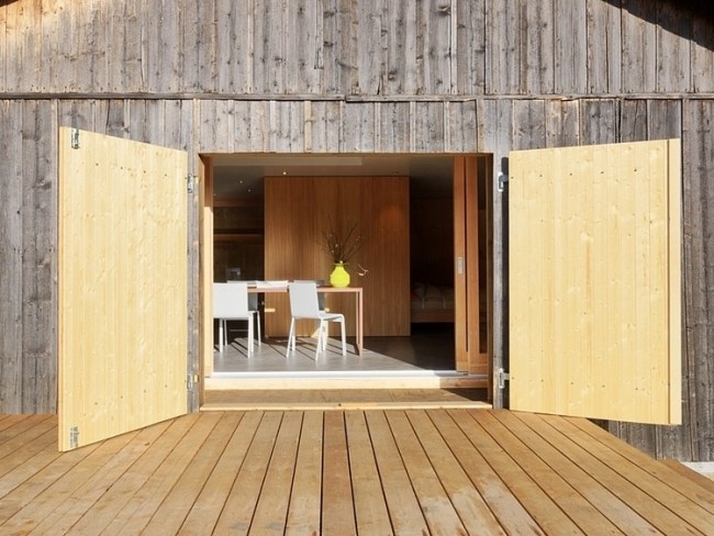 trädäck inifrån vy ombyggd modern fjällstuga i Schweiz
