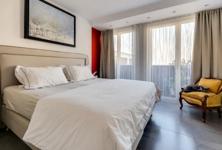 modern-interiör-inredning-sovrum-vind-snygg-grå-vit-vägg-röd-fönster-fönster-dörr-fåtölj