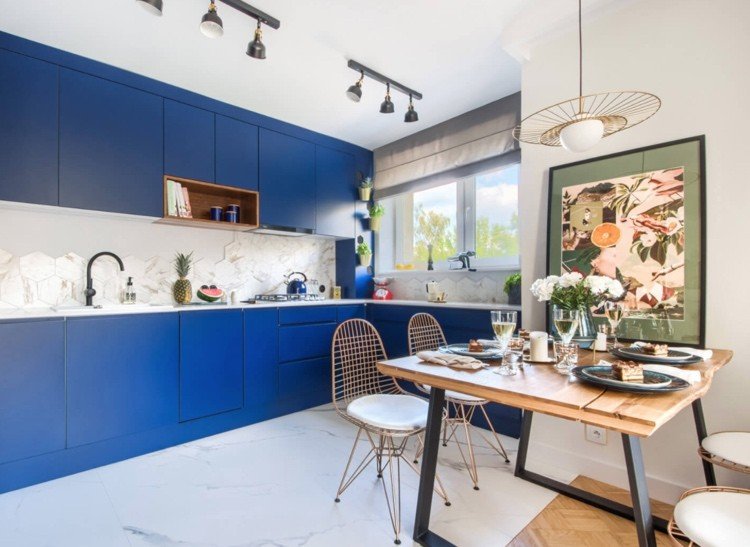 Mörkblått kök i kombination med vita bänkskivor och golvplattor