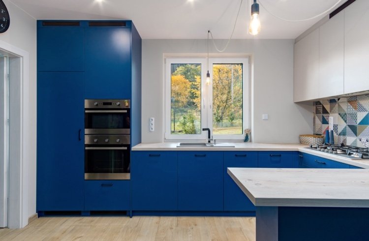 Kök i blått och grått med ett geometriskt mönster för kakelspegeln